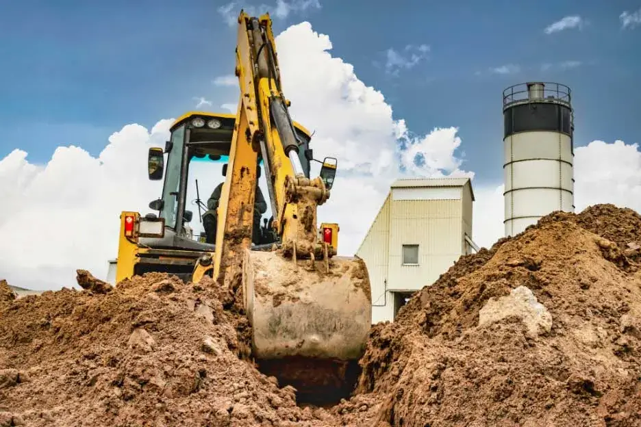 Licensed C12 Contractor excavating the earth using heavy machinery.