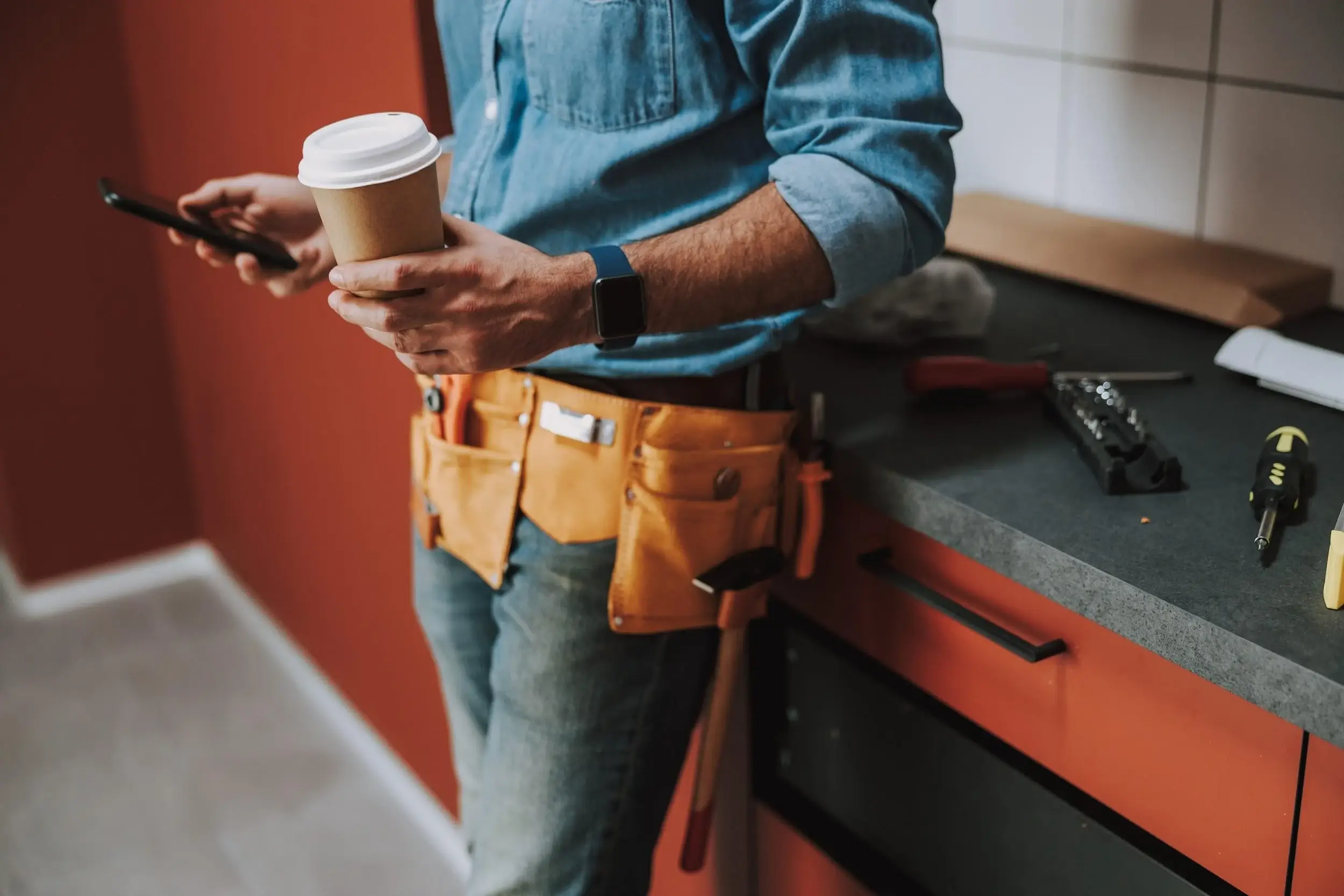 Plumber using a mobile app to study for the California C-36 contractor exam between service calls.